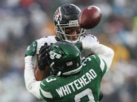 a football player is catching a ball in the rain